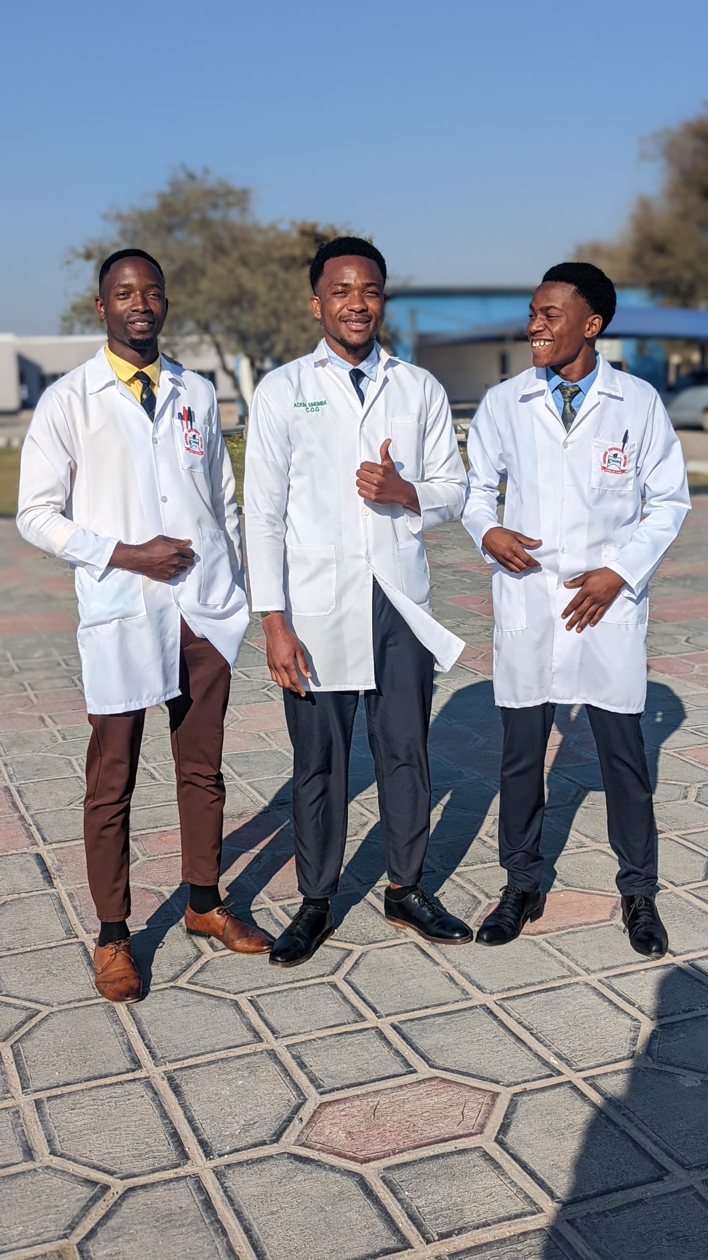 Three male health-sciences students in laboratory coats